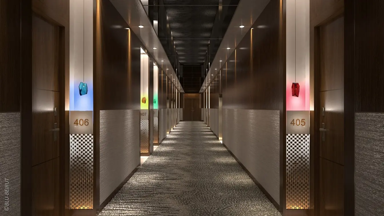 Hotel corridor with sculptural walls and gemstone-colored room indicators in this Saudi Arabia luxury serviced residence.