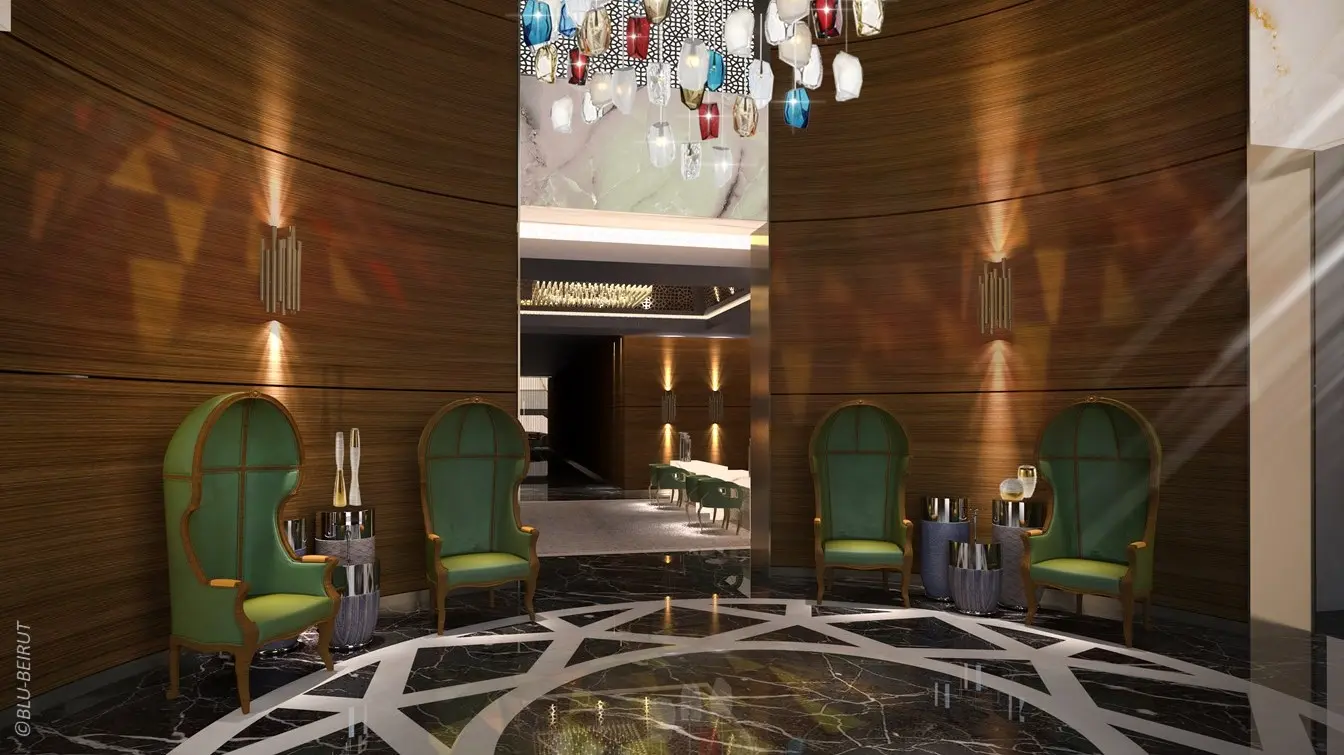 Hotel lobby interior design in Al Khobar with gemstone-inspired chandelier, marble flooring, and custom high-back green chairs by Blu Beirut.